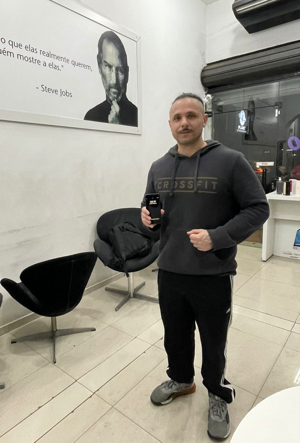 Cliente de moletom preto com o iPhone na loja iPlanet